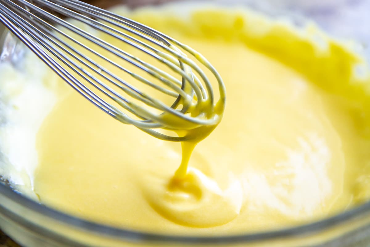Making hollandaise sauce in a glass bowl.
