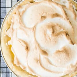 A lemon meringue pie on a cooling rack.