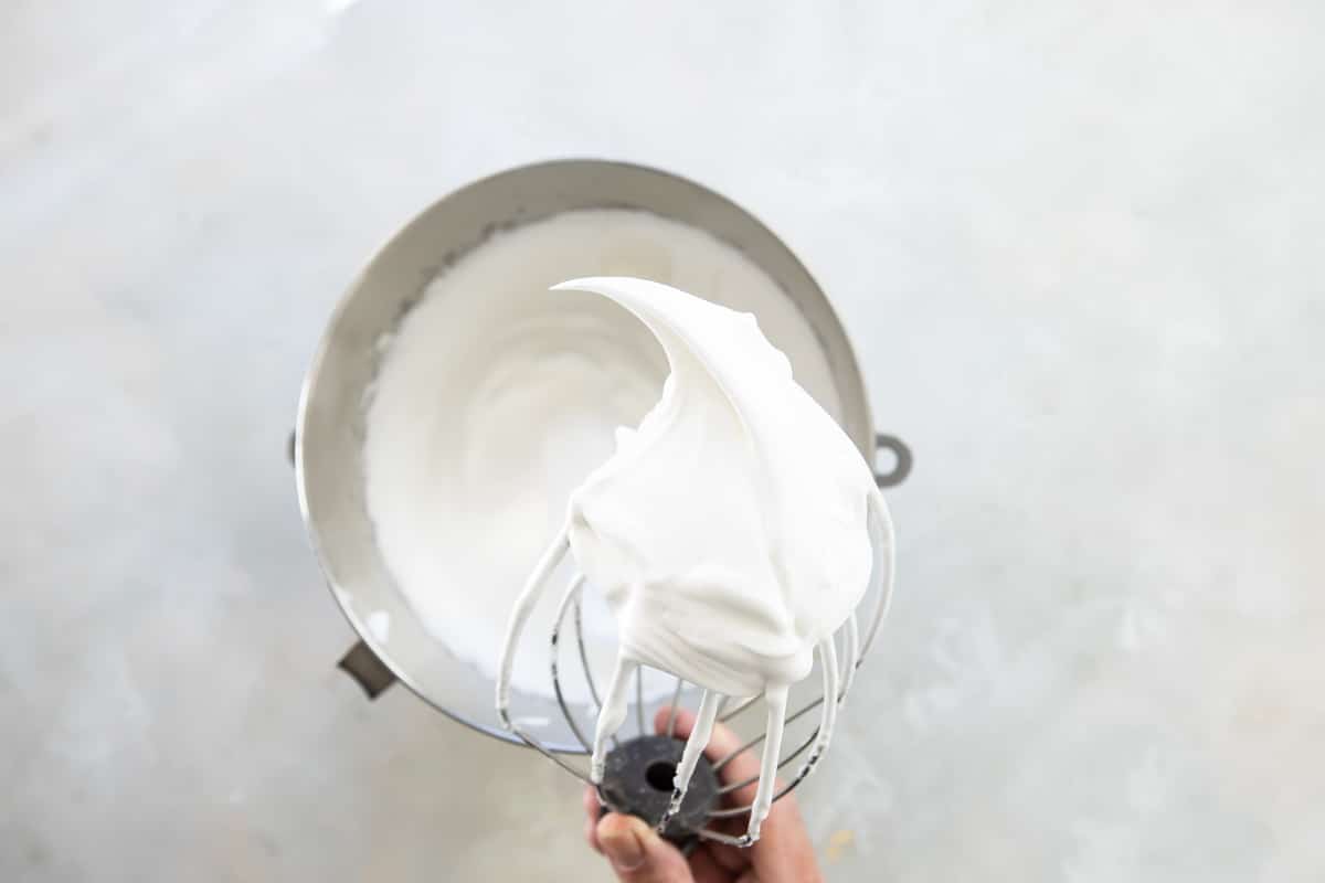 Whipping egg whites in a mixer to make meringue.