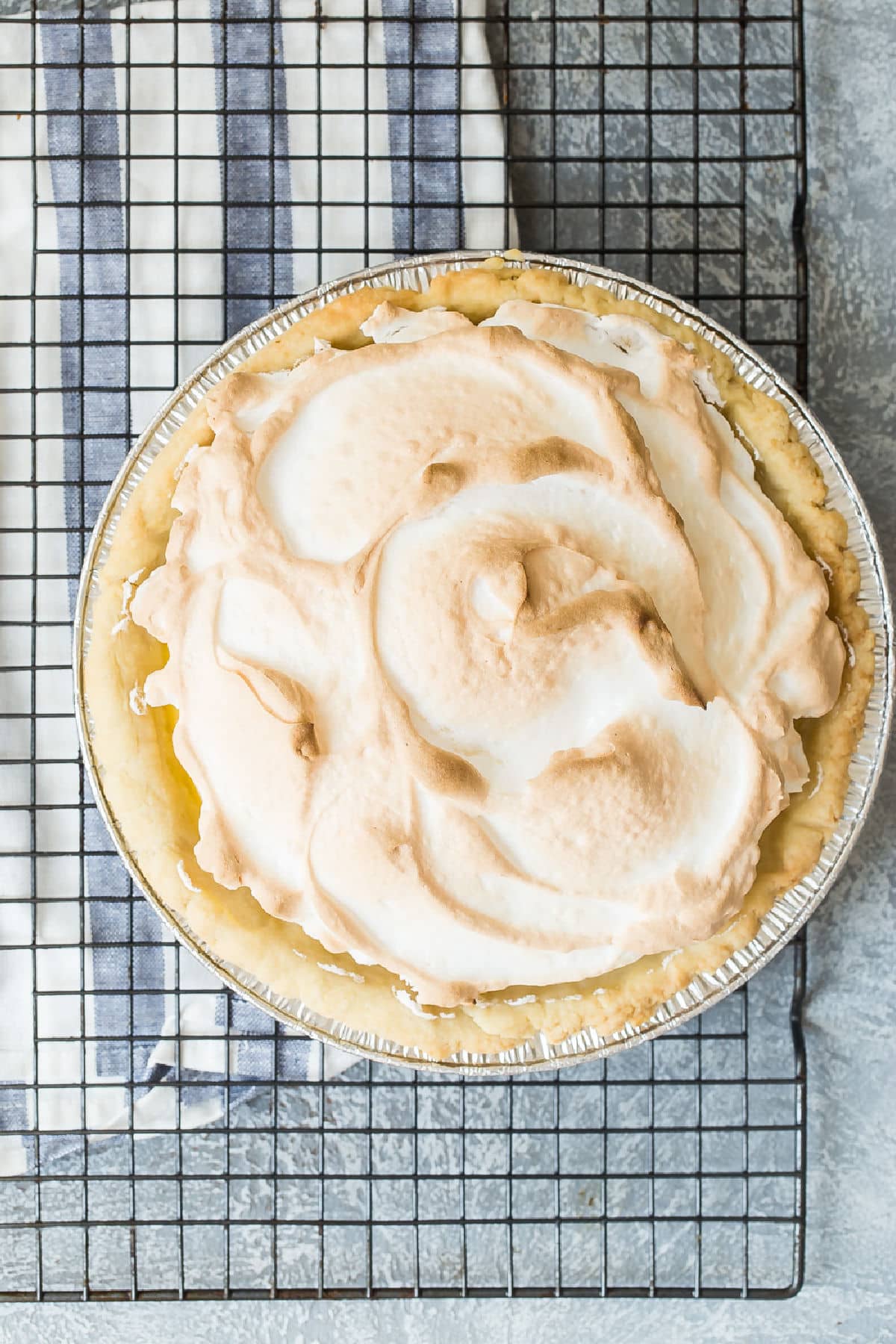A lemon meringue pie on a cooling rack.