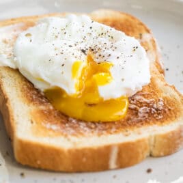 A poached egg on a slice of white toast.