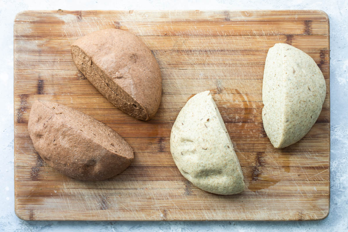 Two rounds of bread dough cut in half.