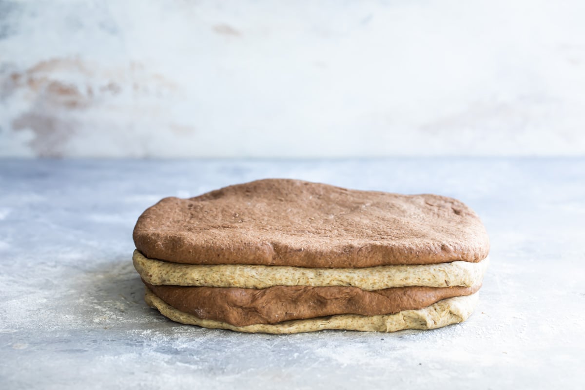 Two rounds of bread dough cut in half and stacked.