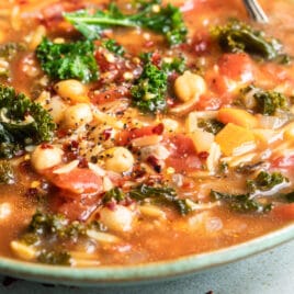 Minestrone soup in a teal bowl.