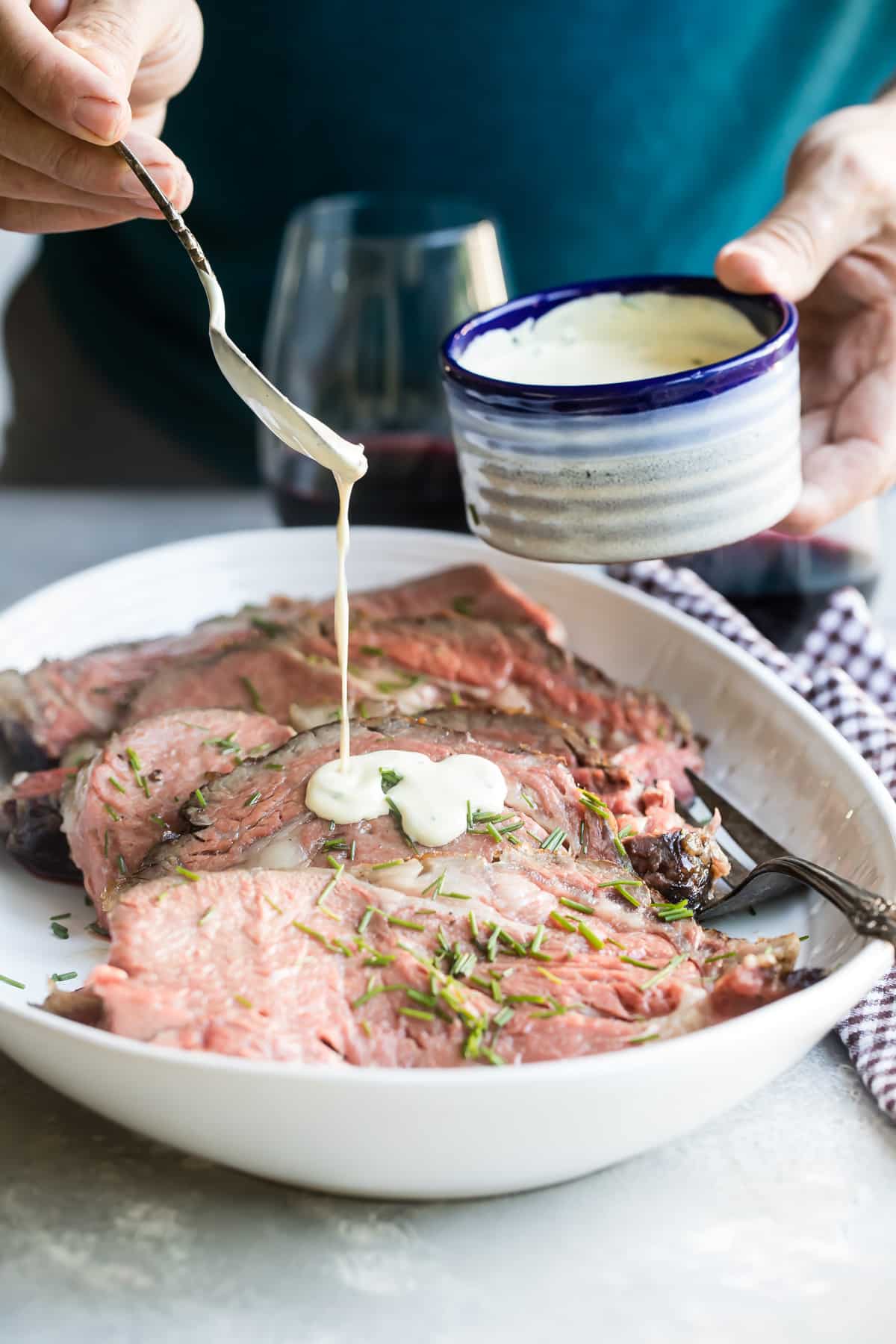 Mustard cream sauce being drizzled over a prime rib.