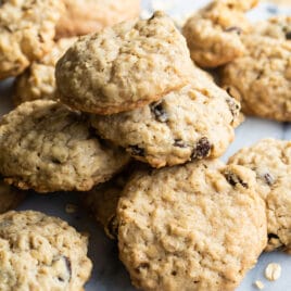 A pile of oatmeal raisin cookies on a marble plattter.
