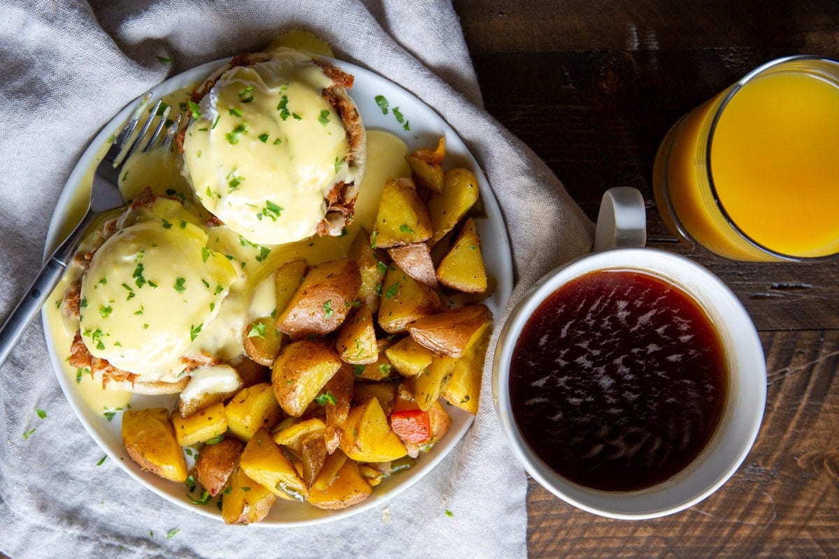 Pulled pork eggs benedict with a side of breakfast potatoes.