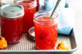 Jars of red pepper jelly on a tray.