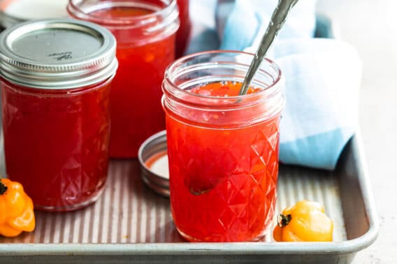 Jars of red pepper jelly on a tray.