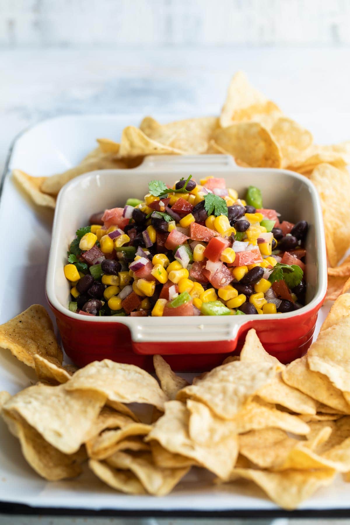 Black bean salsa in a red square dish.
