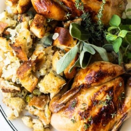 Two cornish hens with stuffing on a serving platter.