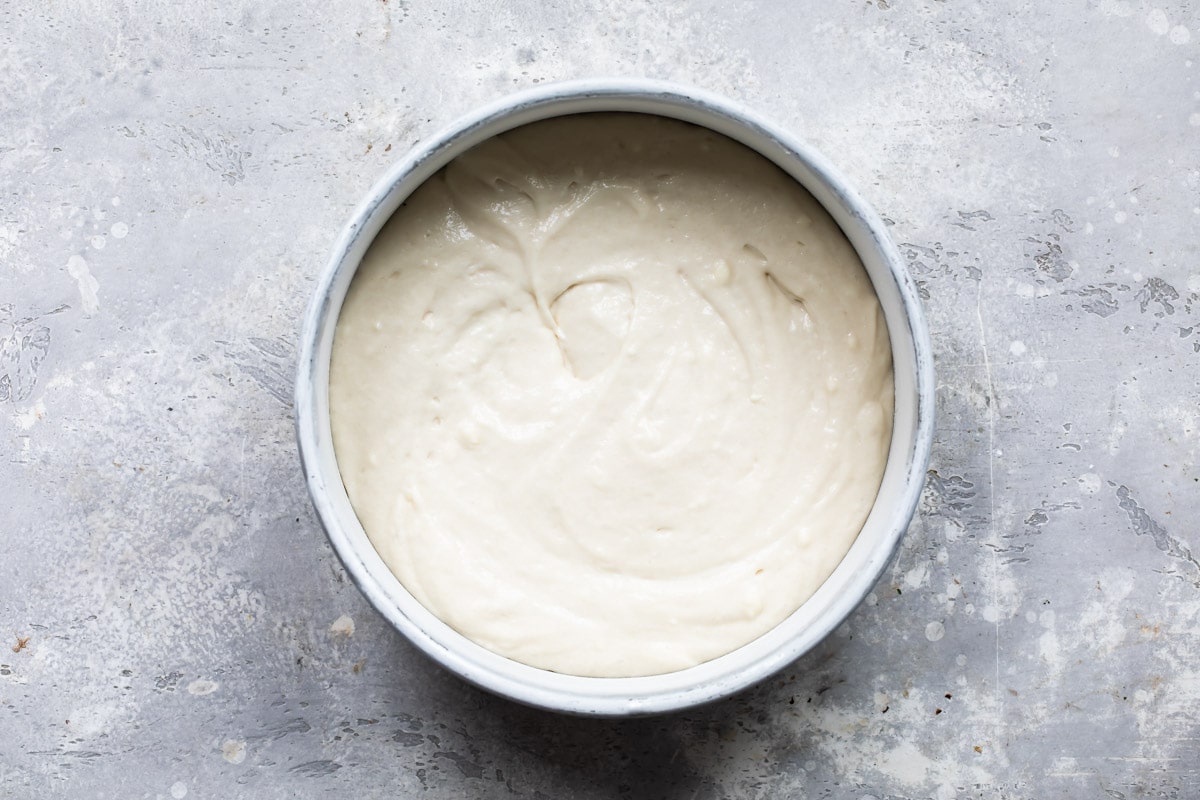 Bunny cake batter in a round silver pan.