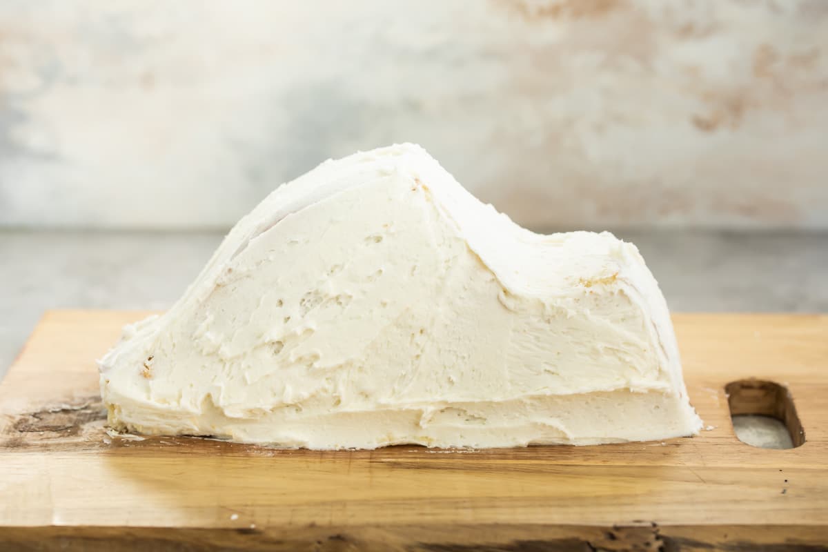 A frosted bunny body on a wooden cutting board.