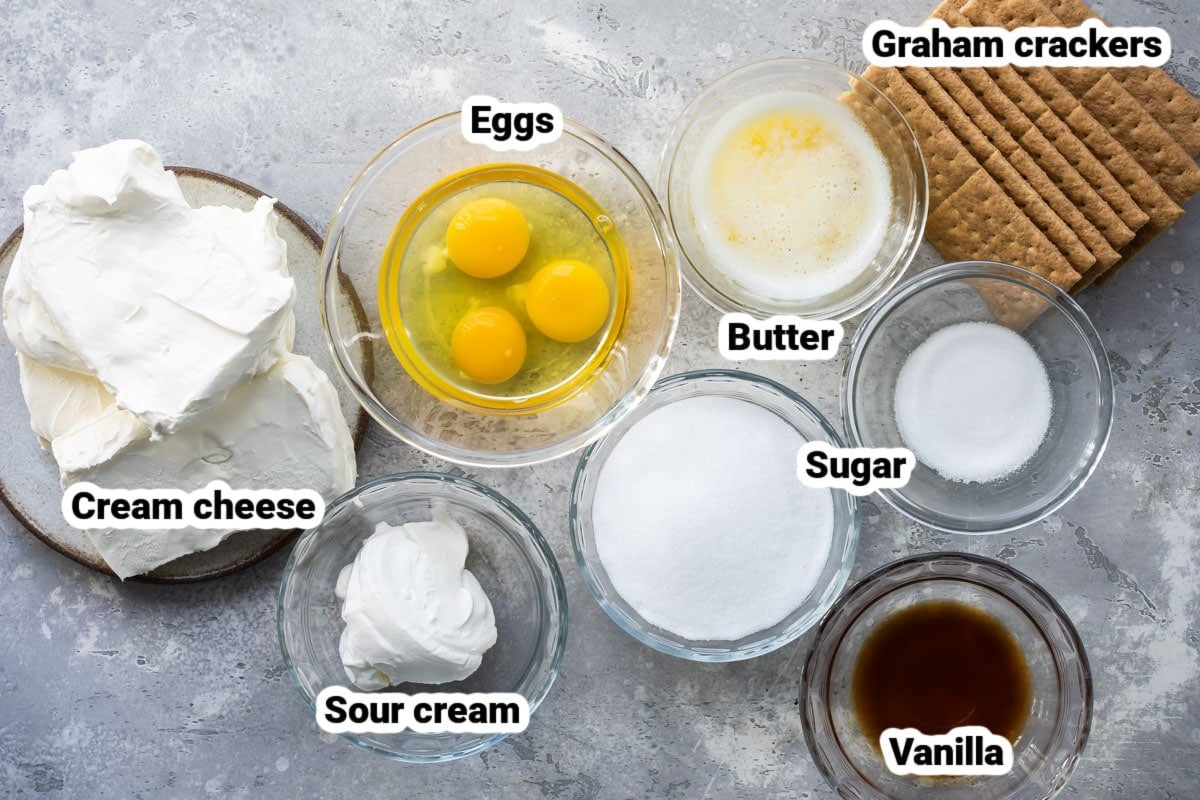 Labeled cheesecake bar ingredients in various bowls.