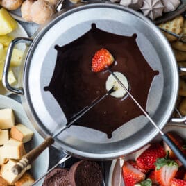 Chocolate fondue served with candy, cookies, cake, and fresh fruit.