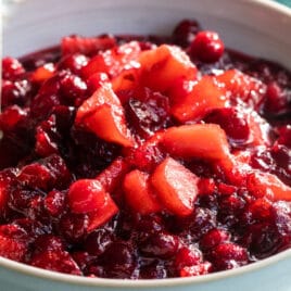 A bowl of cranberry sauce with apples.