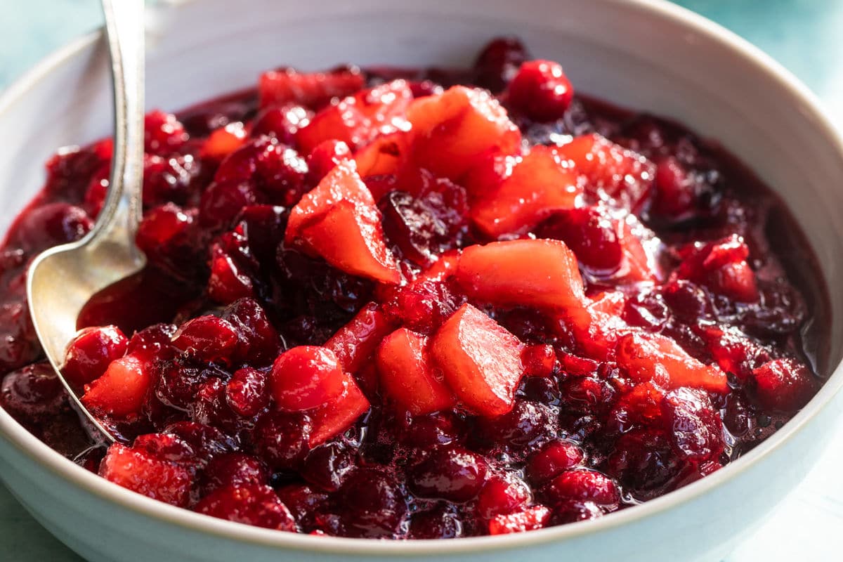 A bowl of cranberry sauce with apples.
