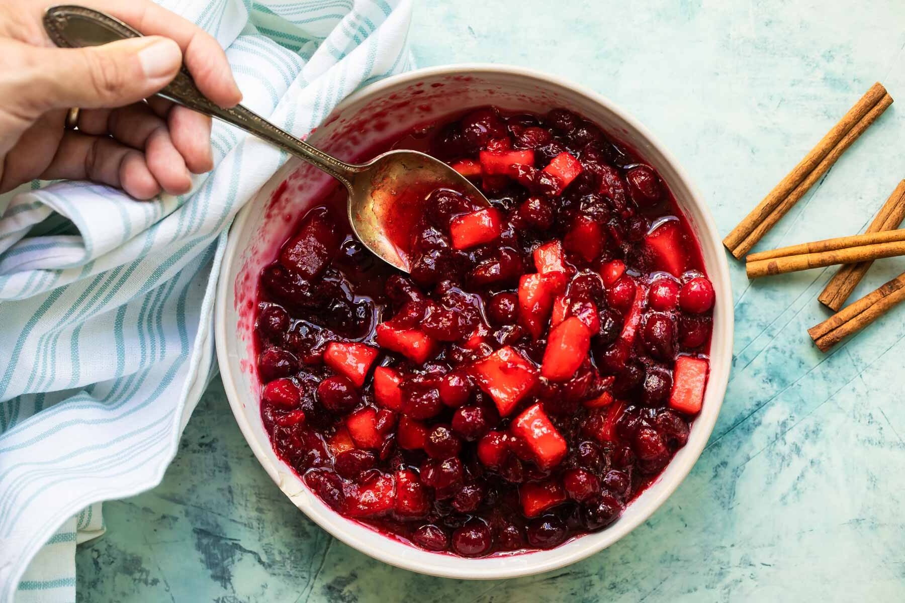 A bowl of cranberry sauce with apples.