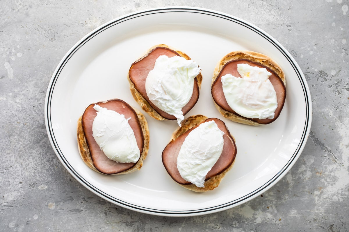 Eggs benedict on a white plate.