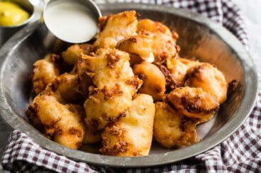 Fried cheese curds in a silver bowl.