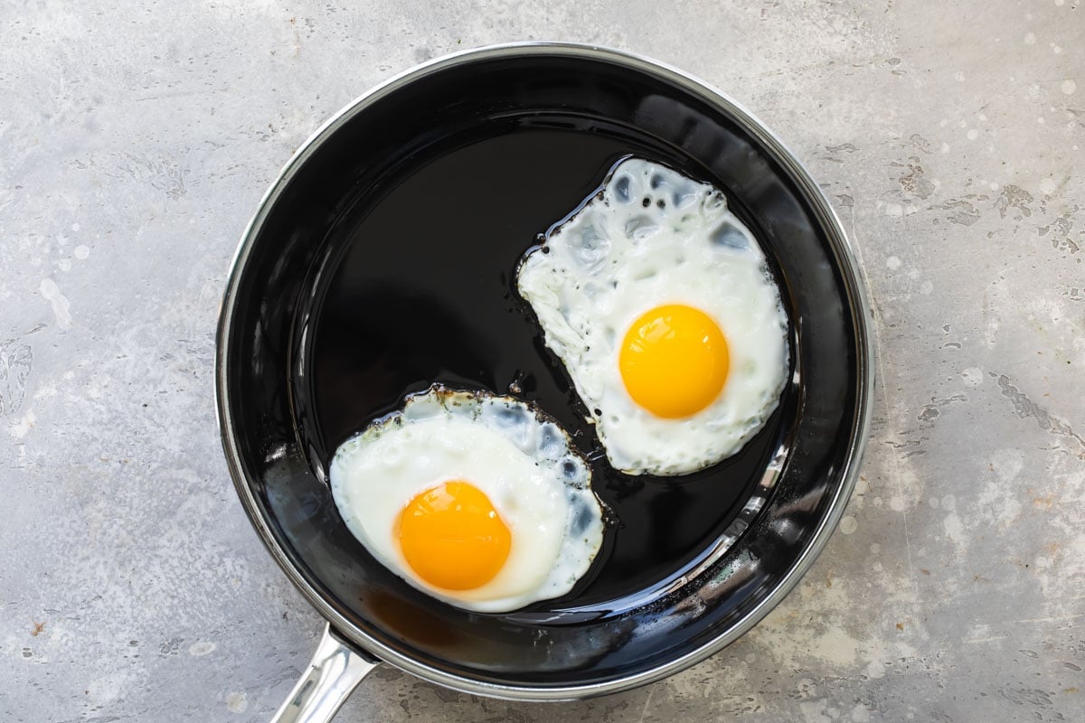 Eggs sunny side up in a skillet.