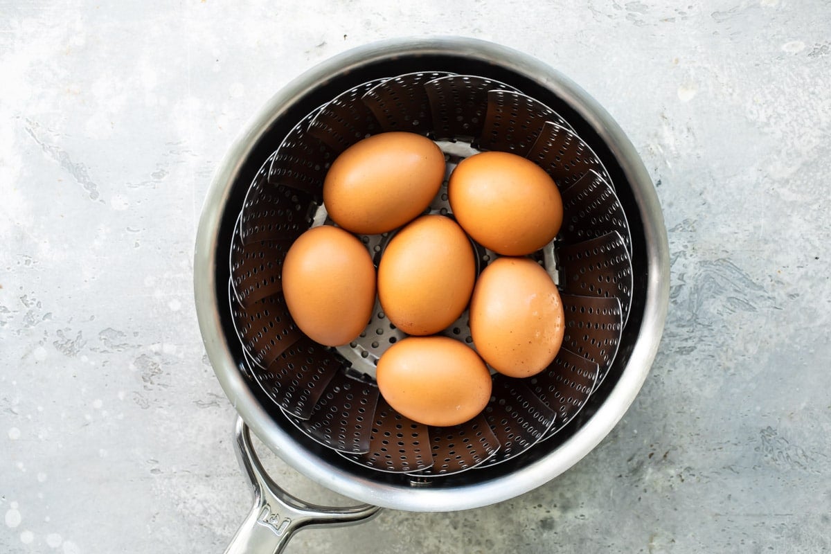Eggs hard-boiling in a pot of water.