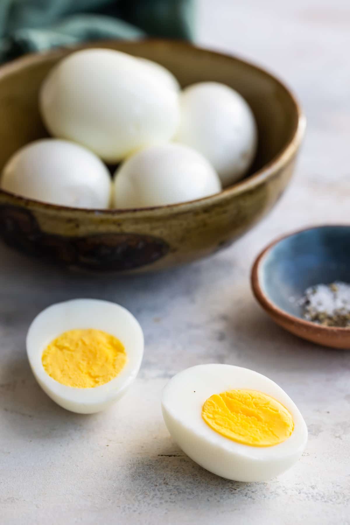 Hard-boiled eggs in a bowl, one split in half in front.