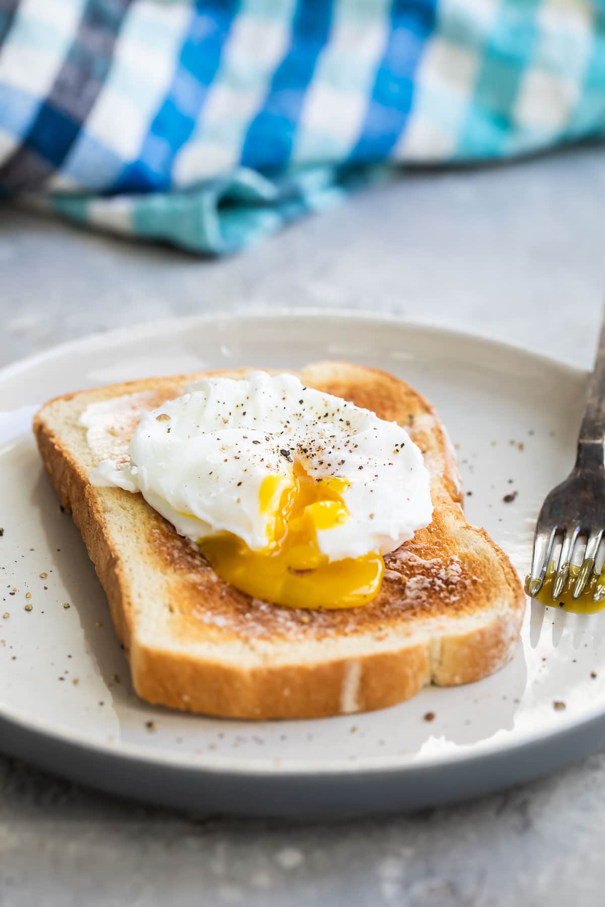A poached egg on a slice of white toast.
