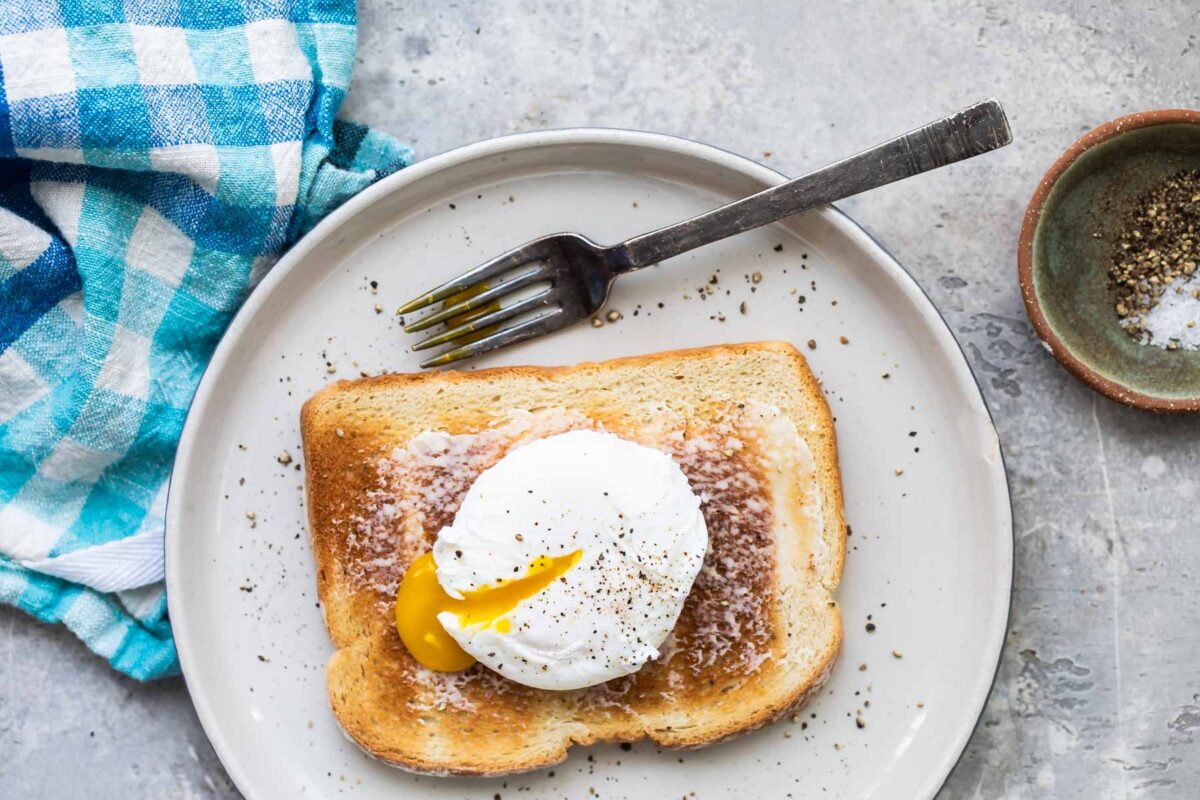 A poached egg on a slice of white toast.