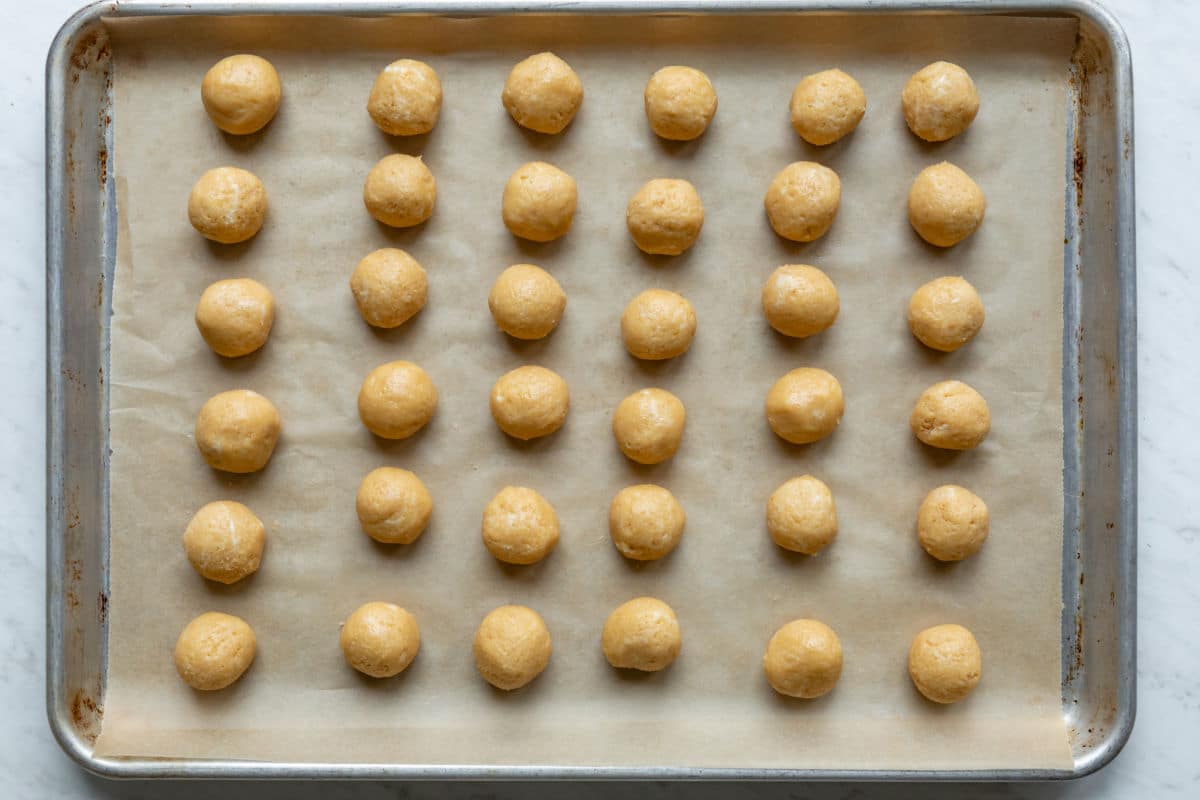 Oreo Cookie balls rolled and set on a baking sheet to freeze.