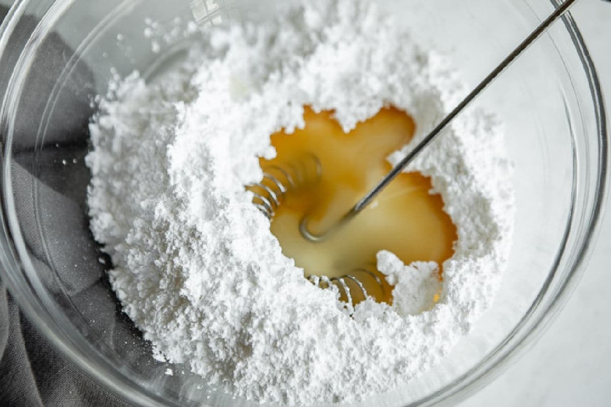 Powdered sugar, vanilla, and milk in a bowl.