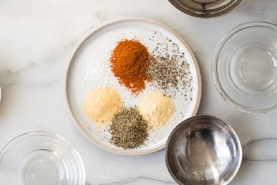Rotisserie chicken seasoning ingredients on a white plate.
