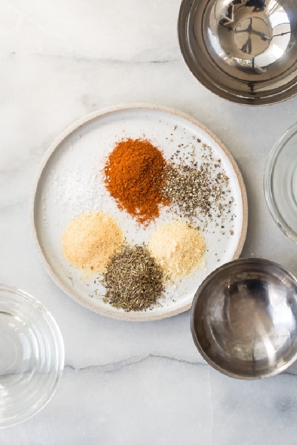 Rotisserie chicken seasoning ingredients on a white plate.