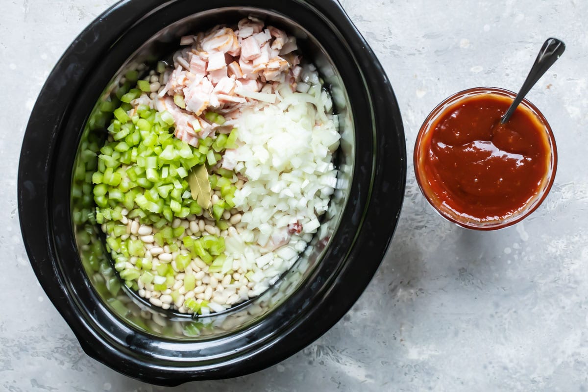 The ingredients for homemade baked beans in a slow cooker before cooking.