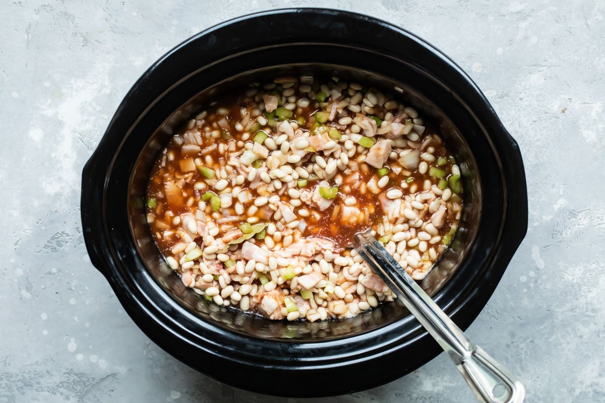 The ingredients for homemade baked beans in a slow cooker before cooking.