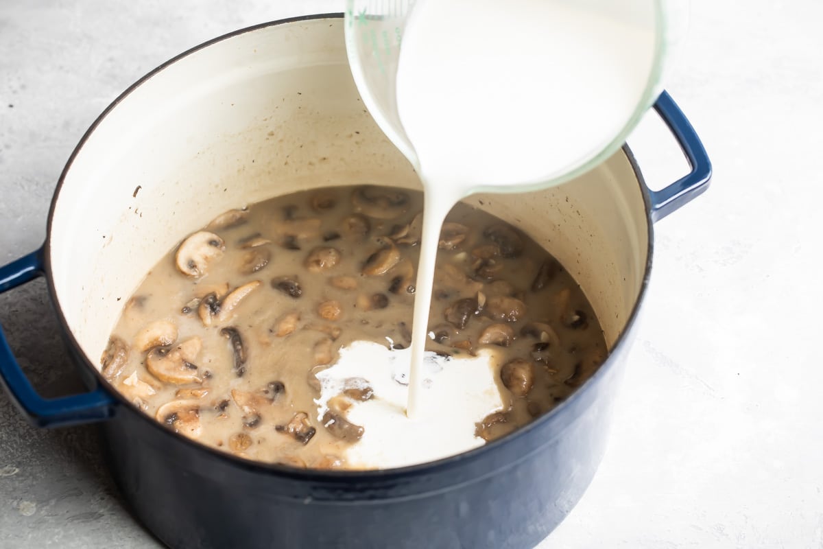 Adding cream to mushroom soup.