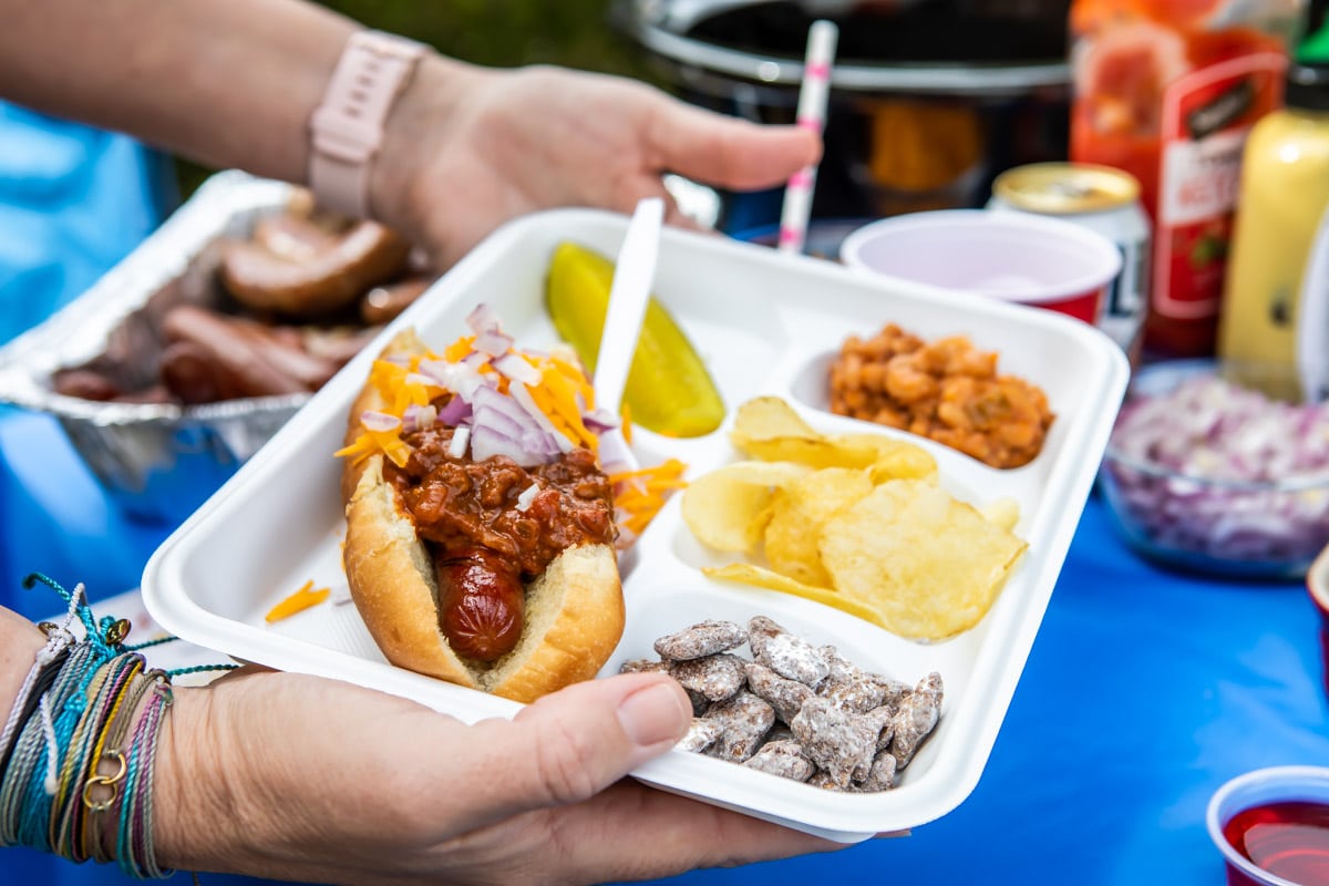A white divided plate filled with tailgating foods.