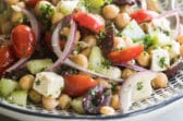 Chickpea salad on a black and white serving platter.