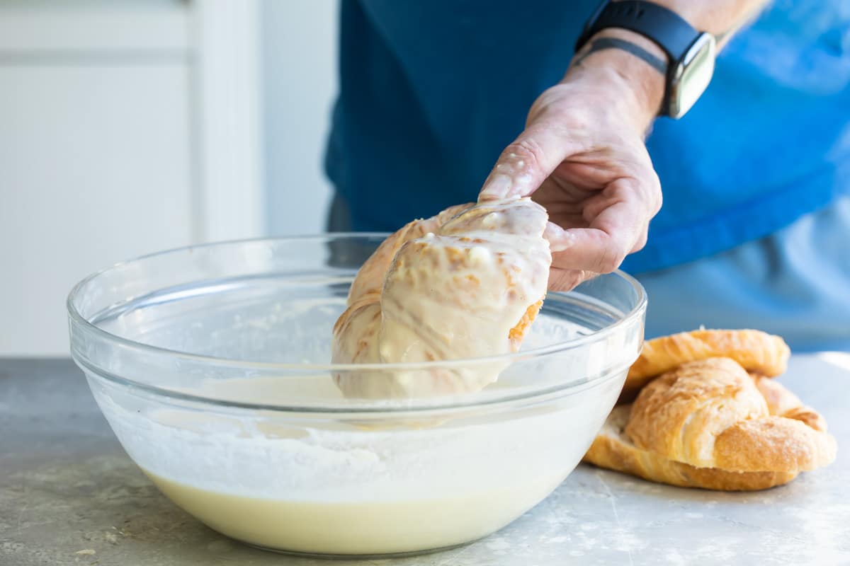Dipping a croissant in French Toast batter.