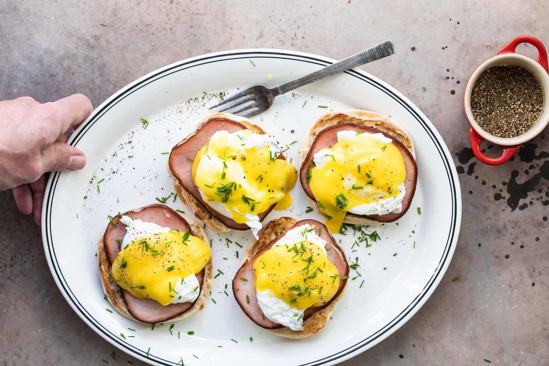 Eggs benedict on a white plate.