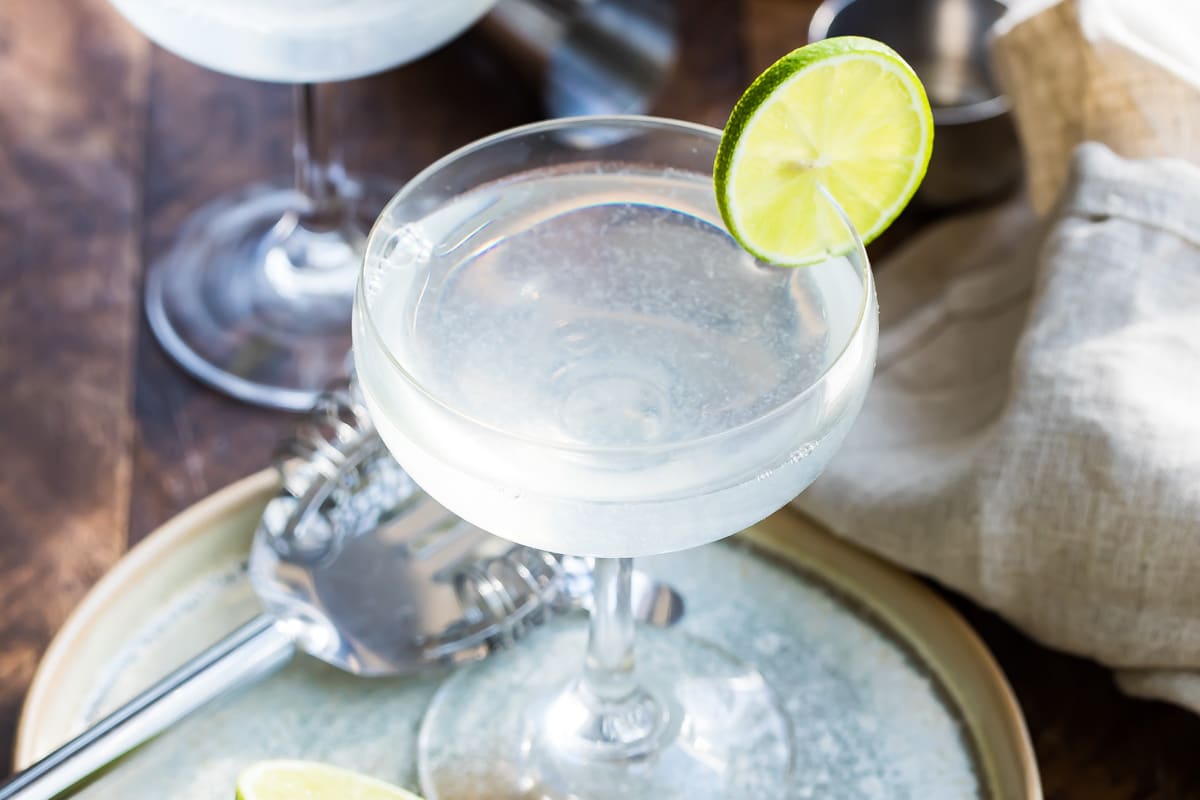 Gimlets in stemmed glasses with lime slices.