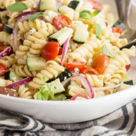 Greek pasta salad in a white bowl.