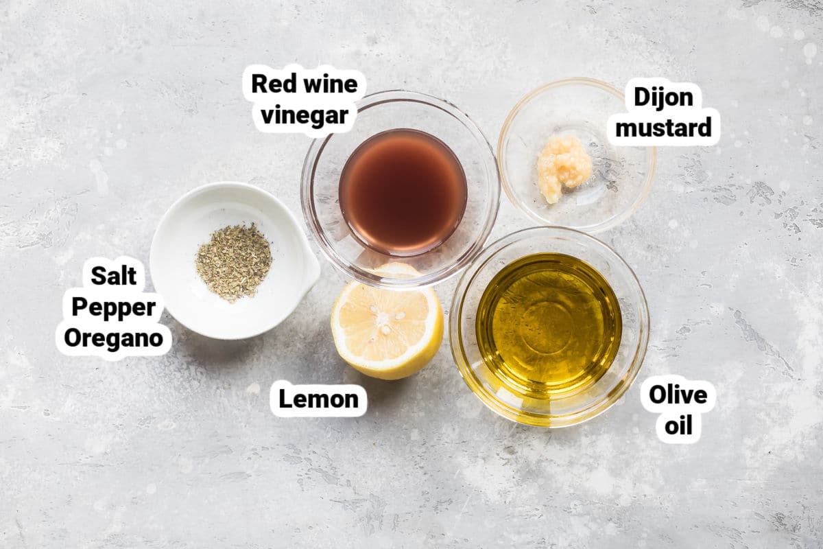Greek salad dressing ingredients labeled in bowls.