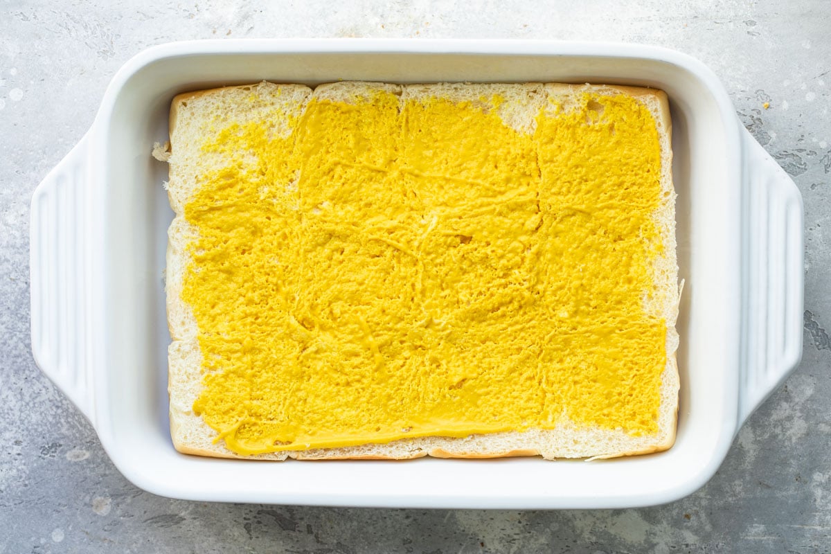 Building ham and cheese sliders in a baking dish. 
