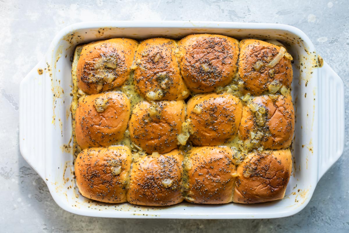 A baking dish of ham and cheese sliders.