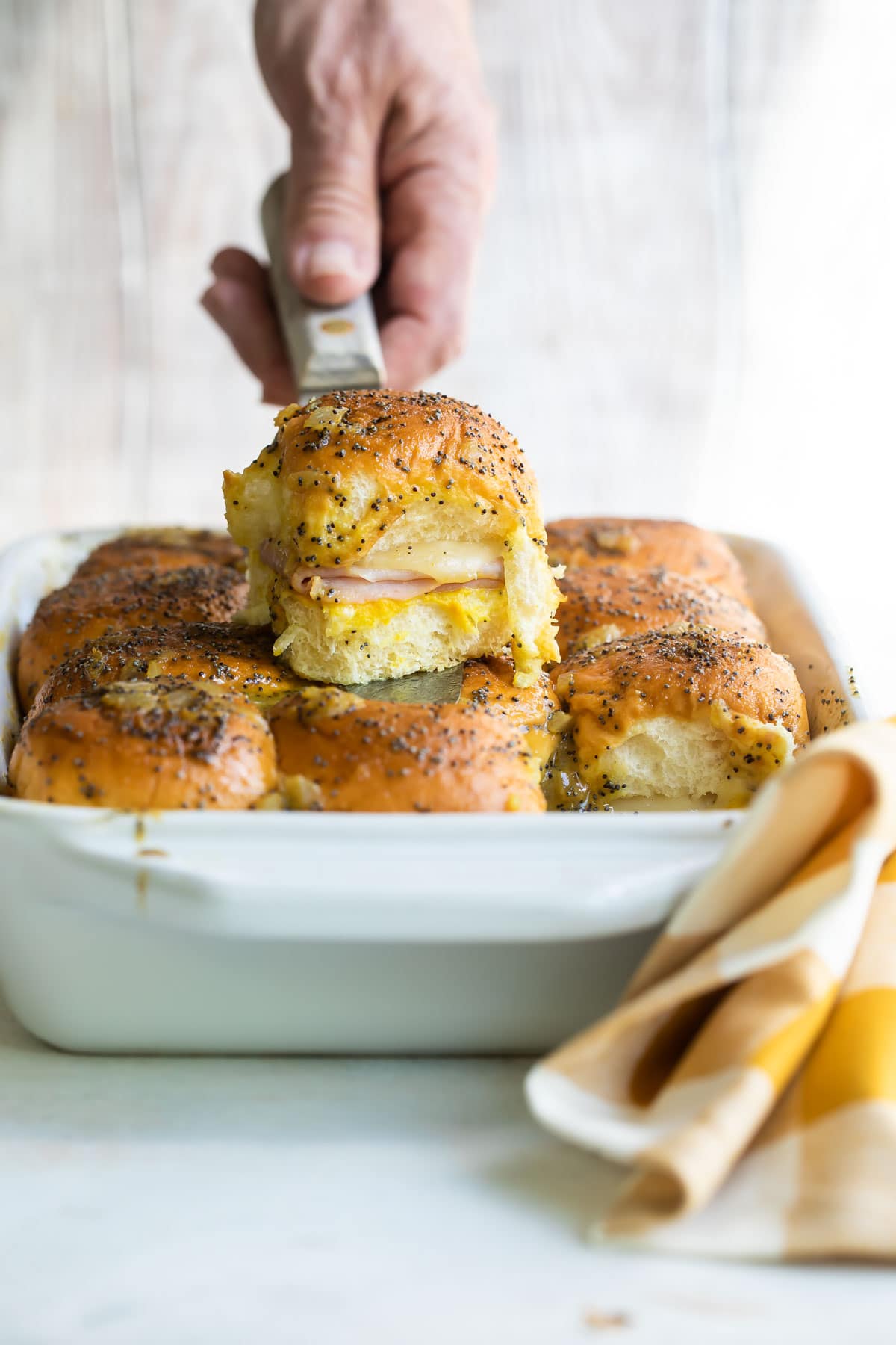 A baking dish of ham and cheese sliders.