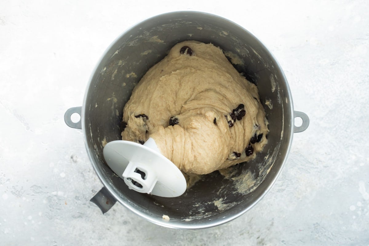 Hot cross bun dough in a silver mixing bowl.