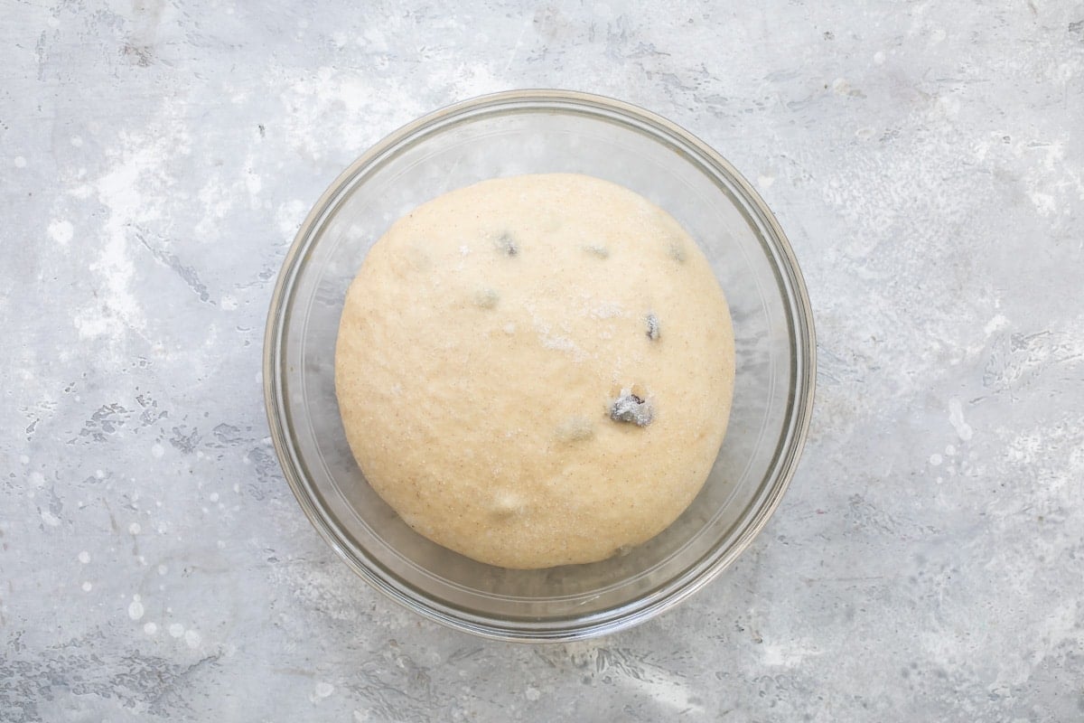 Hot cross bun dough in a clear bowl.