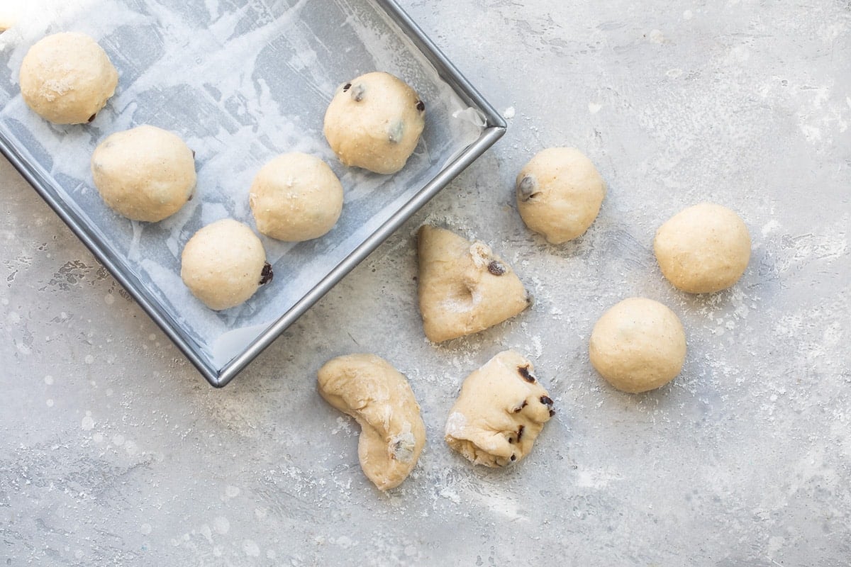 Hot cross bun dough being kneaded into individual balls.
