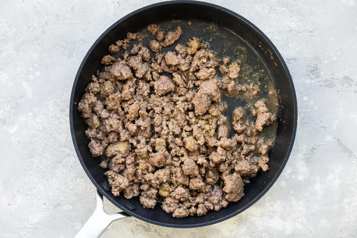 Ground beef cooking in a skillet.